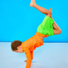 Child doing headstand while wearing neon green swim trunks with a neon orange waistband.